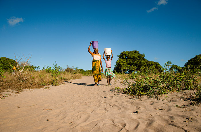 祖母と水を汲んで、歩いて持ち帰る8歳の少女。安全な水をいつでも手に入れられるしくみはまだまだ足りない　©WaterAid/ Eliza Powell