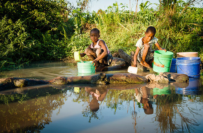 保護されていない水源から水を集める少年たち。地球上のすべての人が清潔な水を利用できるようにしたい　© WaterAid/ Eliza Powell