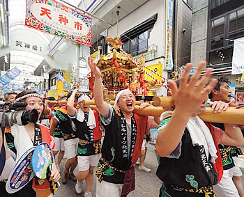 大阪・天神祭／商店街を神輿が練り歩く。