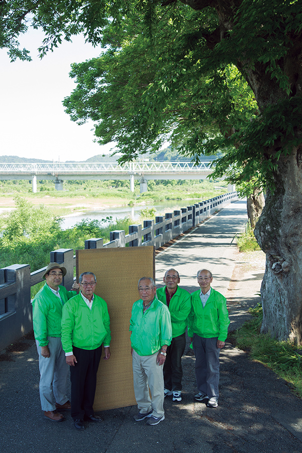 昨夏に畳堤を活用した兵庫県たつの市正條自治会の皆さん。揖保川沿いに設置された畳堤の前で