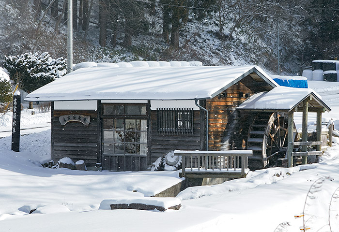 雪をかぶった髙家領水車。「森のそば屋」の手打ちそばは、この水車小屋で挽いた粉を用いている