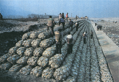 竹籠に石を背負って運ぶ人たち