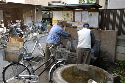 自転車で水を汲みに来た地元の方々