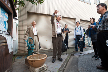 路地尊の水を汲み上げる山田和伸さん