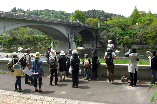 大橋（おおはし）の説明を聞く「ボランティアガイドと歩く広瀬川」の参加者たち