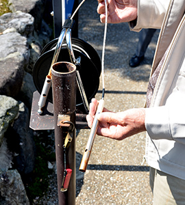 金属製のセンサーを管のなかに差し込む。センサーが着水すると音が出るため、水位がわかる。水位は刻一刻と変化しているという