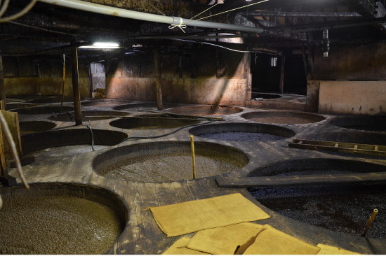 黒島さんの案内で訪れた株式会社ヤマヒサのもろみ蔵。同社は木桶を168本使っている。木桶仕込みは菌が棲みついているため、味や香りが複雑になる。かき混ぜるとプツプツと酵母が発酵していた