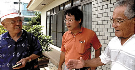 左から沖縄市観光協会顧問の中宗根健昌さん、沖縄県雨水利用市民の会の上原辰夫さん、この家の主の神里興盛さん。