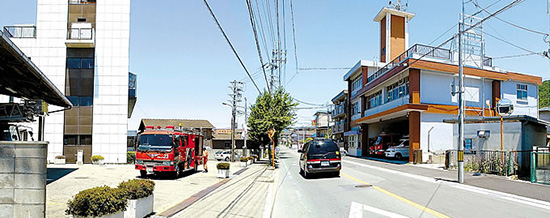 道路の左が消防本部、消防団本部。右が南消防署。