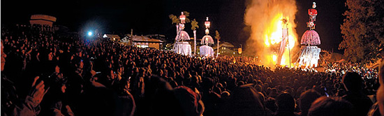 勇壮な火祭りとして、日本三大火祭りの一つとされる道祖神祭りのクライマックス。男の初孫誕生を祝って奉納される初灯籠（花灯籠）がよく燃え上がると、子供が健康に育つといわれている。「撮影台に乗られますか？　乗って撮影されるなら腕章が必要です」と森さんが教えてくれたのは、テレビカメラをはじめとする取材陣がベストポジションで撮影ができる撮影台