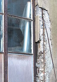 外壁のコンクリートが「爆裂」した状態。窓はスチールサッシ。