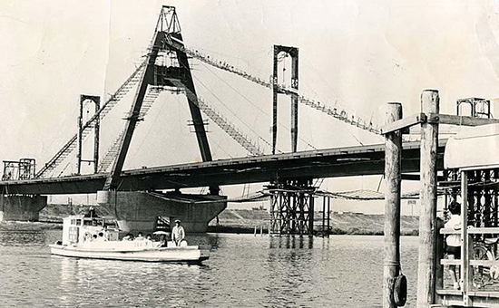 1969年（昭和44）の淀川を渡る平田の渡しと、建築中の豊里大橋。