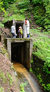 天保堰は、巨大な岩山にトンネルを掘ることで通水している。