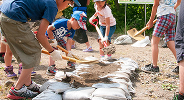 子どもたちでも持てる小さい土嚢袋を使って、土嚢の積み方を習う。