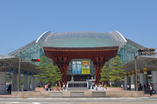 金沢駅兼六園口（東口）にある差し出す雨傘をイメージしたガラスのドーム「もてなしドーム」（奥）と、伝統芸能に使われる鼓をイメージした「鼓門」（手前）