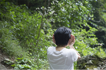 両耳に手を添えて、滝と反対側を向く。坂﨑さんおすすめの音の楽しみ方