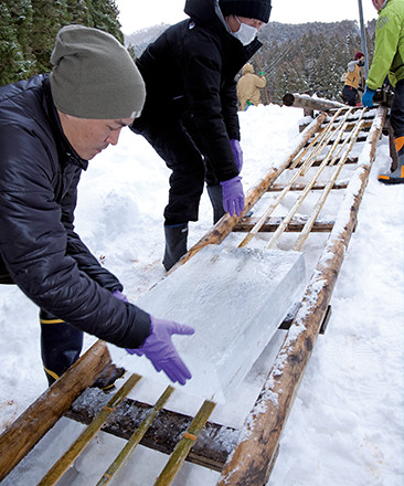 切り出した氷は竹のレールで滑らせながら運ぶ。氷の重さは約40kg