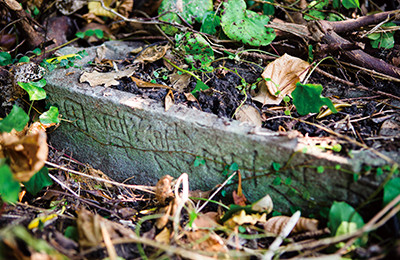 田島から働きに来て生月島で亡くなった「田嶋（島）磯屋佐助」の墓石。横倒しにしているのは風化を防ぐため