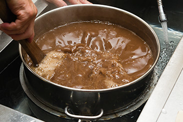 鍋から寸胴に移し、水を流しながら41度になるまで冷やす。寒天と餡が分離しないように、かき混ぜる手を休めない