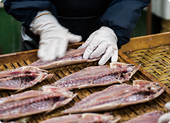 水洗いした魚を手でなでる。