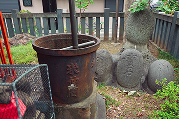 佐賀稲荷神社の境内にある力石（右）と天水桶（左）