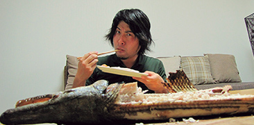アリゲーターガーを食べる平坂さん。微妙な表情をしているのは、身がパサパサしていて味も薄いから
