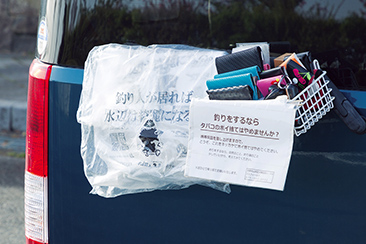 釣り人のマナーアップのために、川村店長が配布するオリジナルごみ袋と携帯用灰皿。取材中に一人の釣り人がごみ袋を持ち帰った