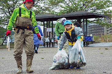 琵琶湖畔を清掃する釣り人たち。大人に混ざって奮闘する子どもの姿も