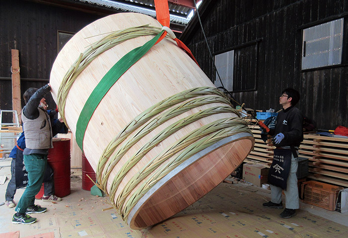 木桶づくりの作業風景。編んだ竹たがで側板を締め、底板にかんなをかけるなど数多くの工程がある。「木桶職人復活プロジェクト」には120名が加入し、毎年少しずつ増えている（提供：ヤマロク醤油株式会社）