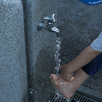 公園の水で足を洗う子ども。こうして水が使える陰には不断の努力がある
