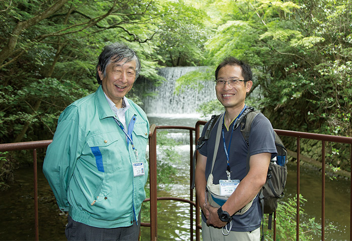 「分水堰堤」で微笑む神戸市水道局計画調整課専門官の松下眞さん（左）と同水質試験所の清水武俊さん（右）