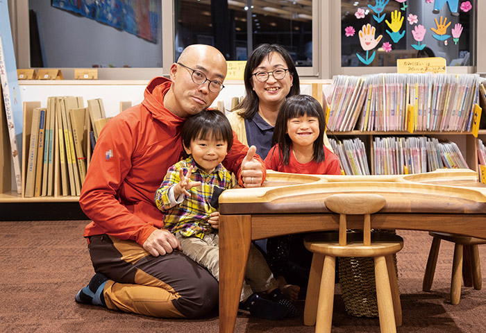 大塚友記憲さん（左）、祐子さん（右）ご家族。2018年7月にオープンした東川町の複合交流施設「せんとぴゅあⅡ」の図書室にて