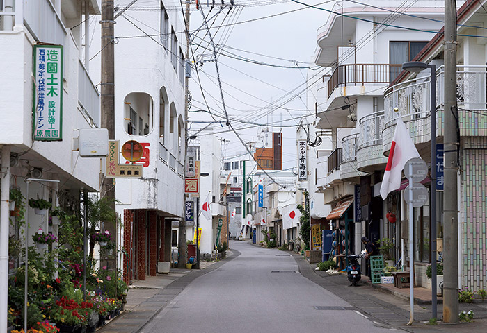 与論島の中心市街地、茶花のまちなみ。のんびり散歩するのにちょうどいい規模。この日は憲法記念日だったため国旗が目立つ