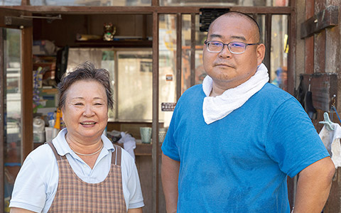 小松石の加工に井戸水を使っている有限会社 芦澤石材の芦澤潤さんとお母さん。潤さんの祖父が水を探して居を定めたと言う