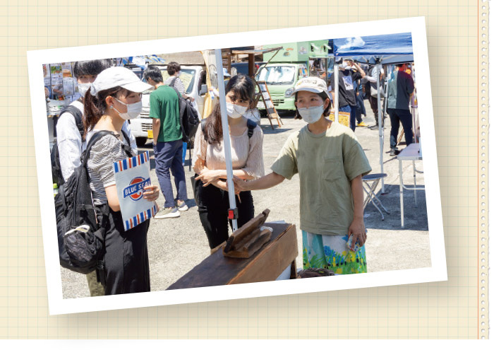 「真鶴なぶら市」で真鶴出版の來住友美さん（右）に話を聞くゼミ生たち