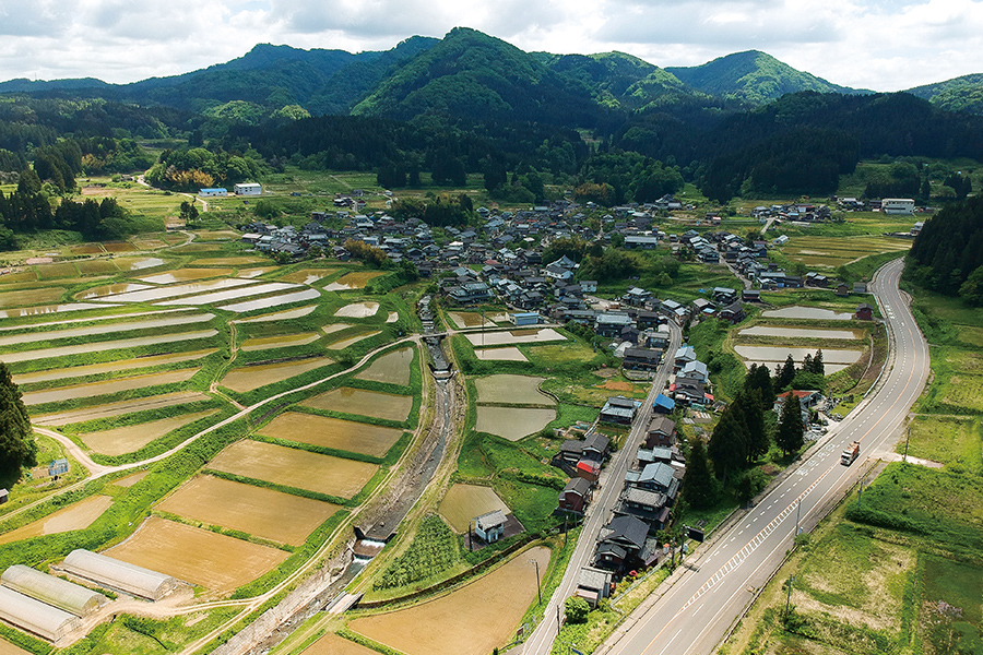 上空から見た大毎集落。水源は写真の奥にある。左手前に向かって流れているのは大毎川