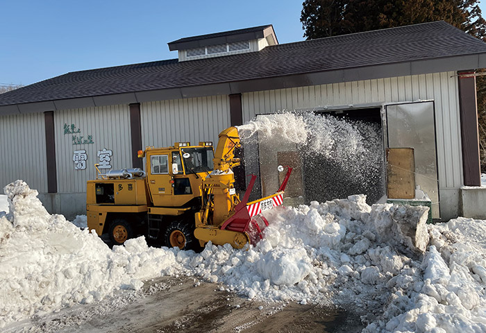 「雪室」に雪を投げ入れる除雪車。ここで玄ソバを熟成させる　提供：喜多方市山都総合支所