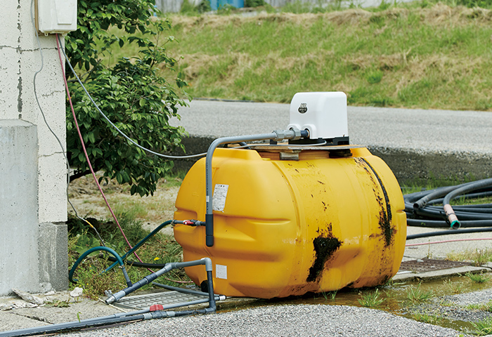 センターの横に設置されている大型のポリタンクと小型のポンプ。「シャワーも浴びたいよね」と自作したものだ 