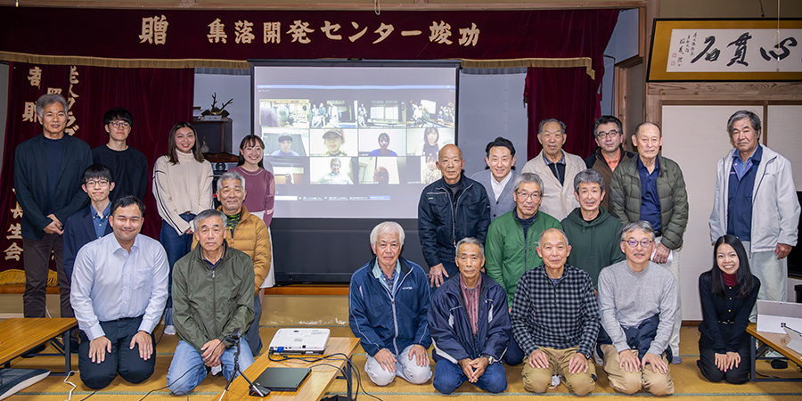 研究成果発表会にご参加いただいた大毎集落の皆さんと野田ゼミ発表者、ミツカン若手社員。後方のスクリーンには就職活動やインターンなどで当日参加できなかった学生たちの姿も映っている