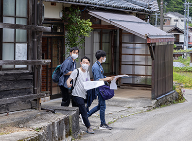 大毎集落を調査する野田さんと一杉さん、田渕さん