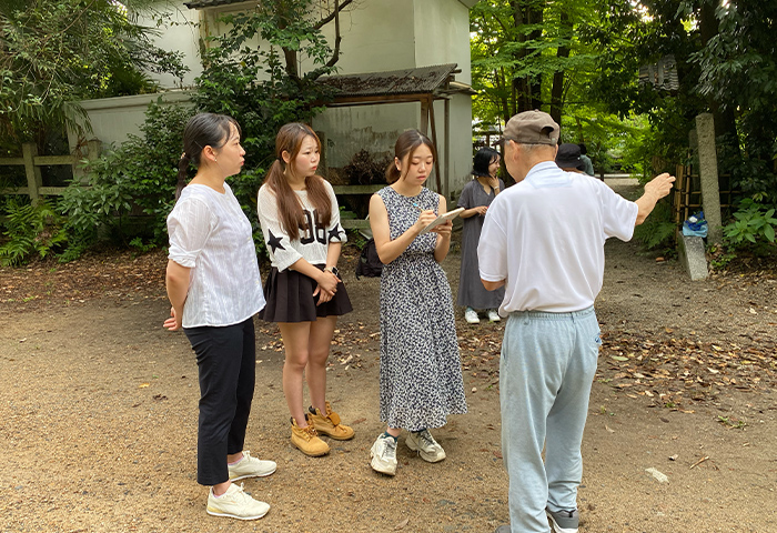 梨木神社付近で毎朝行われるラジオ体操参加者にヒヤリングする学生と若手社員。
