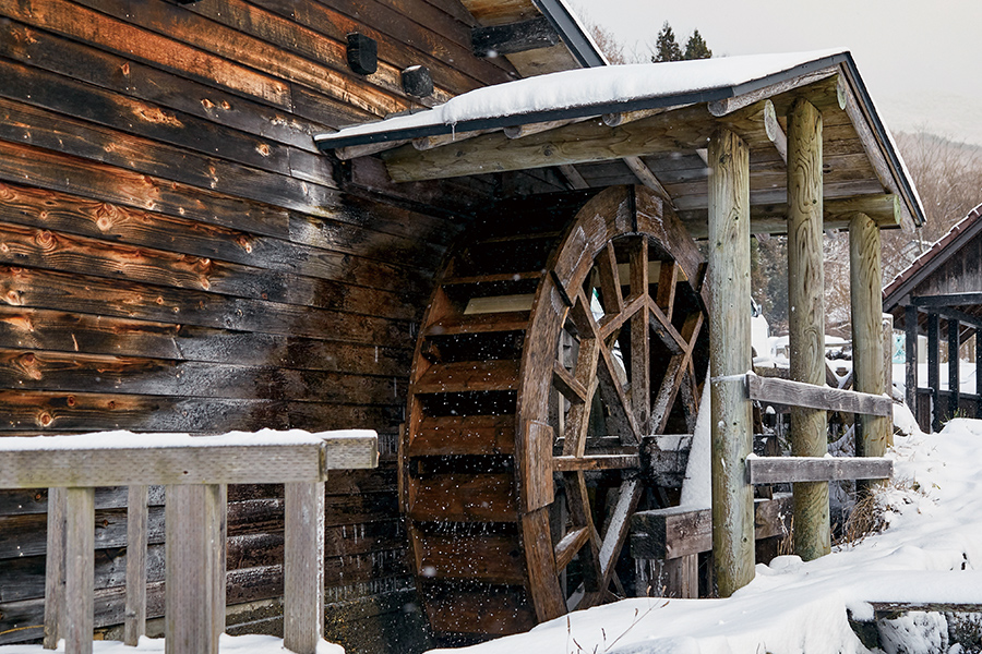 雪が舞うなかよどみなく回る「森のそば屋」の水車。この動力を用いてそば粉を挽く